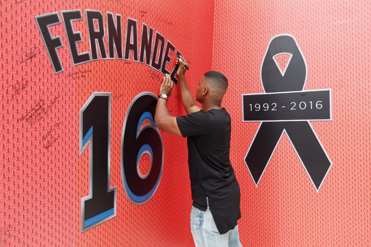 Image: A fan signs the memorial mural as he mourns the death due to a boating accident of Miami Marlins pitcher Jose Fernandez, outside Marlins Park prior to a game against the New York Mets in Miami