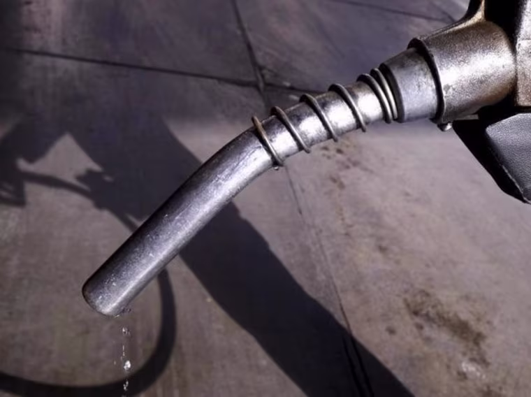 Worker grabs a nozzle at a petrol station in Tehran