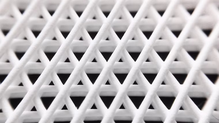 Scanning electron micrograph from a small region of a Hyperelastic Bone scaffold that was explanted from the back of mouse after more than 30 days. The micrograph shows the cross-section of a single Hyperelastic fiber (circular region in center) being surrounded by and becoming integrated with biological tissues.