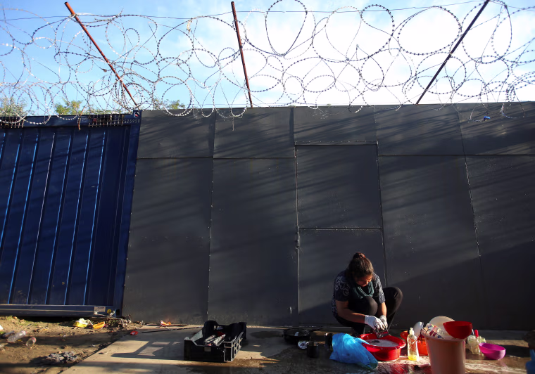 Image: A refugee woman washes clothes on the Hungary-Serbia border