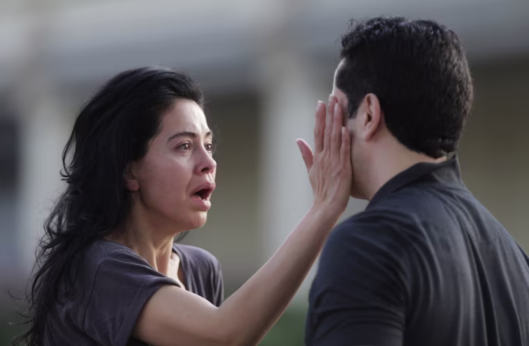 Image: Jennifer Molleda looks at the blood specked face of her husband after a shooting