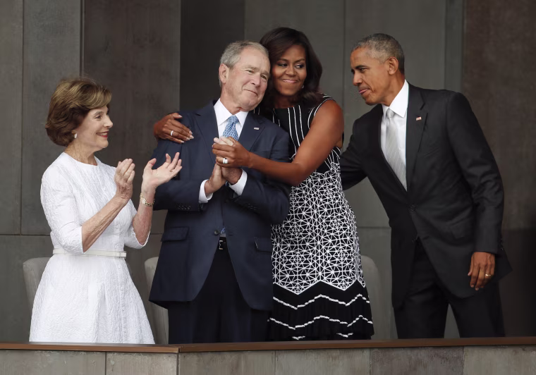Image: First lady Michelle Obama hugs former President George W. Bush at the dedication ceremony of the Smithsonian Museum of African American History and Culture