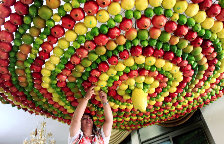Image: Woman from the Samaritan sect decorates with fruits and vegetables a traditional hut known as a \"sukkah\", which is a ritual hut used during the Jewish holiday of Sukkot, on Mount Gerizim on the outskirts of the West Bank city of Nablus