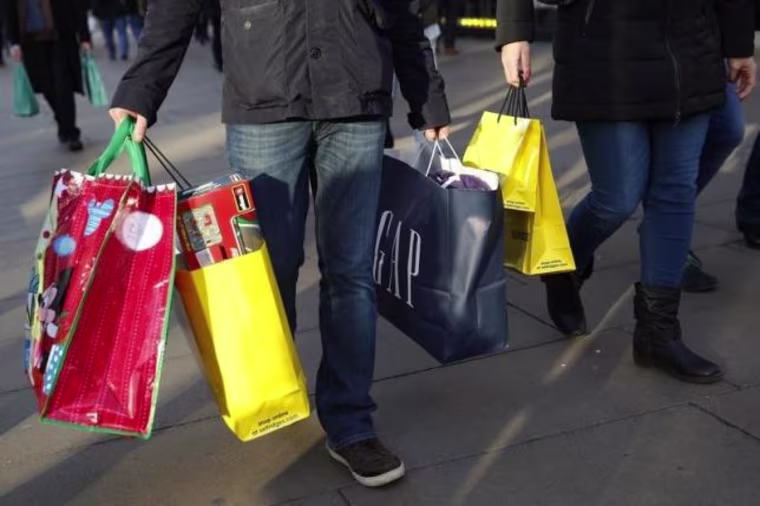 Shoppers carry bags along Oxford street during the final weekend of shopping before Christmas in London