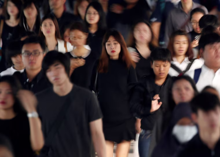 Image: Passengers dressed in black and white or dark coloured clothes o mourn the passing of Thailand's King Bhumibol are seen in Bangkok
