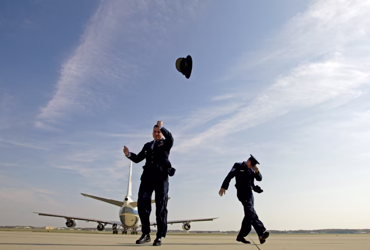 Image: A member of the Air Force loses his hat after a blast from Air Force One