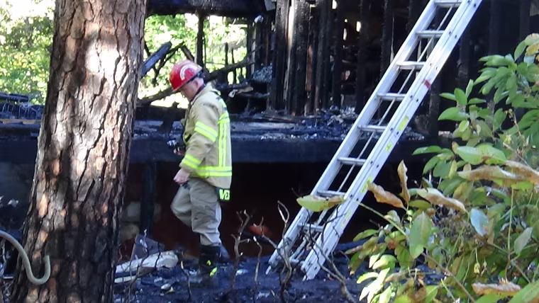 Image: A firefighter inspects the scene of the fire