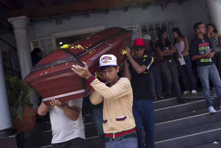Image: Relatives of a crime victim carry his coffin during his funeral ceremony in Caracas