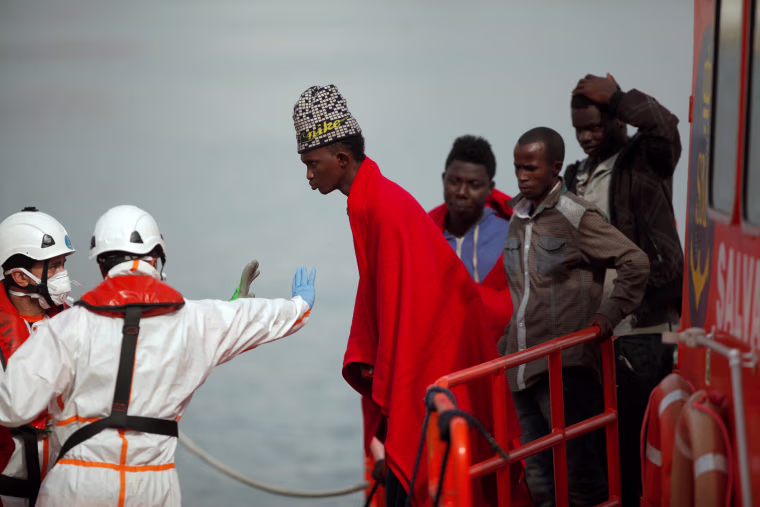 Image: A migrant, who is part of a group intercepted aboard a dinghy off the coast in the Mediterranean sea, is stopped after arriving on a rescue boat at a port in Malaga