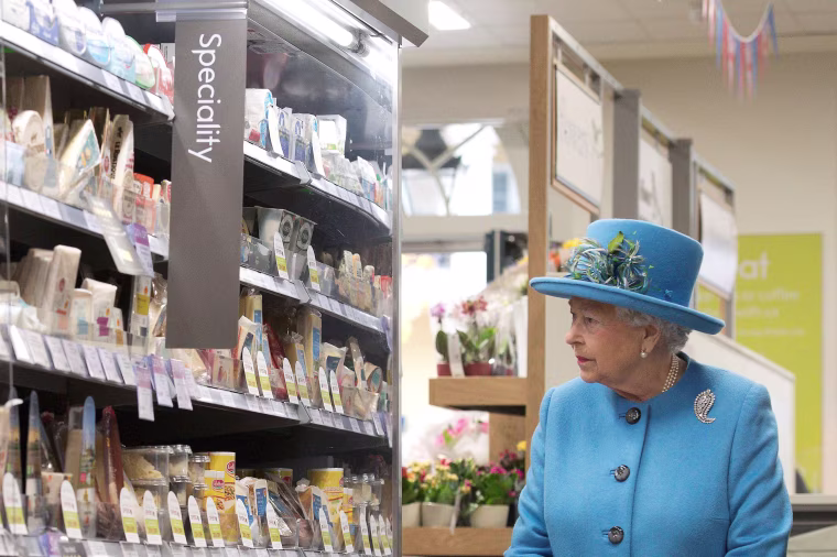 Image: Britain's Queen Elizabeth looks at products on the shelves at a Waitrose supermarket during a visit to the town of Poundbury