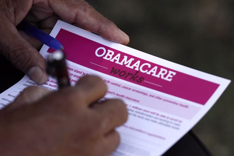 Image: A man fills out an information card during an Affordable Care Act outreach event hosted by Planned Parenthood for the Latino community in Los Angeles, California