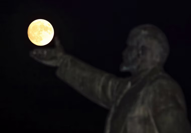 Image: A full moon rises behind a statue of Soviet state founder Vladimir Lenin on the eve of the \"supermoon\" spectacle, Baikonur