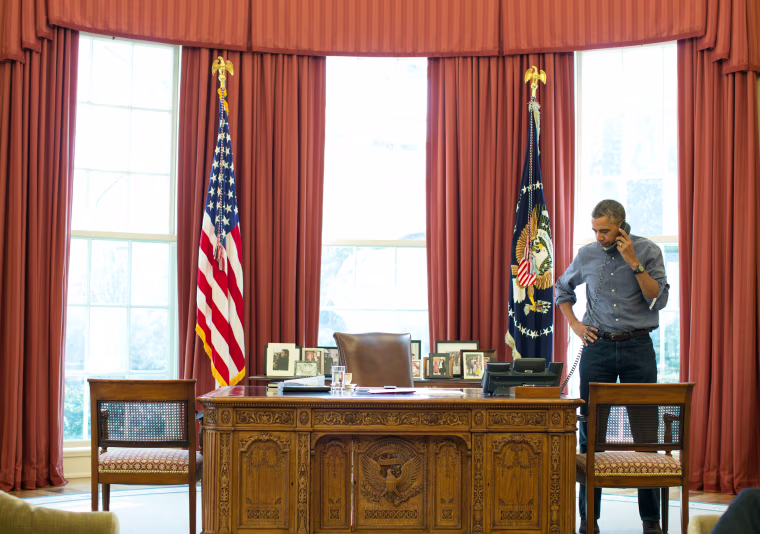 Image: President Barack Obama talks on the phone in the Oval Office with Russian President Vladimir Putin