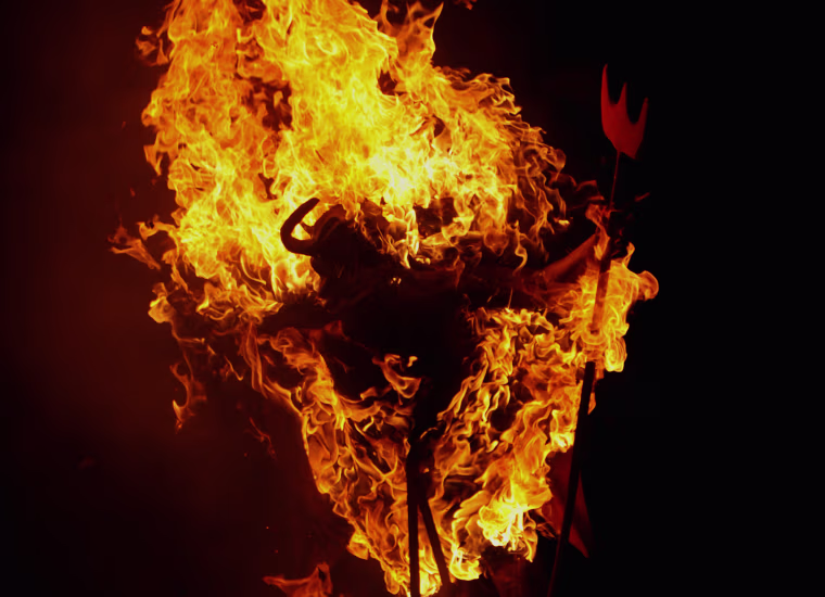 A figure representing the Devil burns on