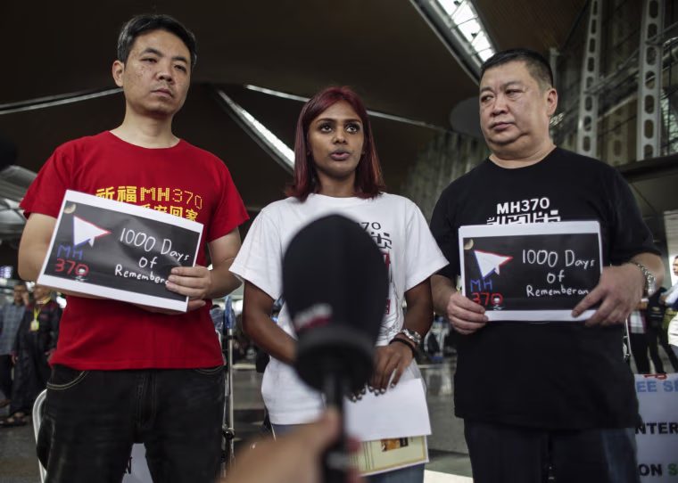 Image: MH370 relatives Grace Subathirai Nathan of Malaysia stands between and Jiang Hui (left) and Bai Shuan Fu (right) from China at Kuala Lumpur International Airport before their trip to Magadascar.