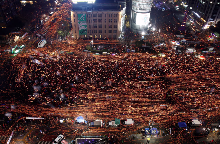 Image: Protesters march with candles at a protest calling South Korean President Park Geun-hye to step down in Seoul