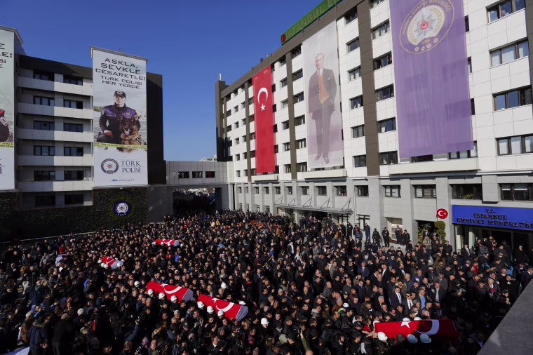 Image: People carry the flag-draped coffins of police officers killed in Saturday's blasts in Istanbul