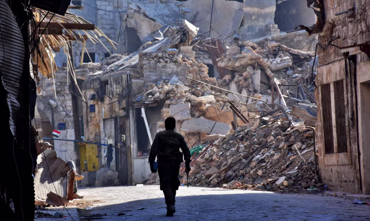 Image: A Syrian pro-government fighter walks past damaged buildings in the Bab al-Nasr district of Aleppo's Old City on Dec. 9.