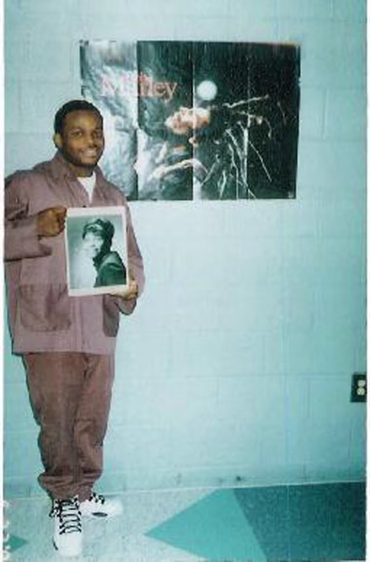 Image: Jimmy Dennis poses while holding a photograph of his mother.