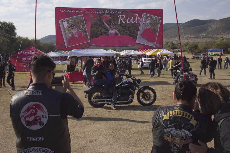 Image: A couple, who traveled from Mexico City with a group of bikers, pose for a photo at Rubi's quinceanera