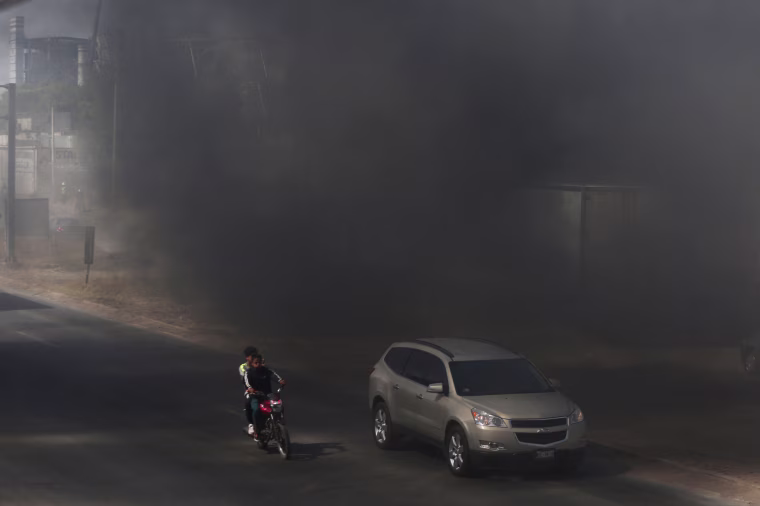 Image: Vehicles pass through a cloud of smoke as tires burn during a protest against the rising prices of gasoline enforced by the Mexican government, at the side of a Pemex gas station in San Miguel Totolcingo, Mexico on Jan. 3.