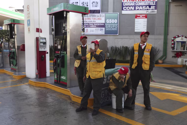 Image: A gas station attendant films demonstrators blocking a main road for about an hour as they protest hikes in gas prices in Mexico City on Jan. 4.