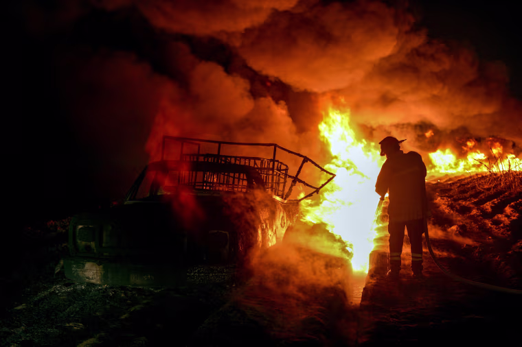 Image: Firefighters work to quell a fire on an alleged clandestine gasoline storage