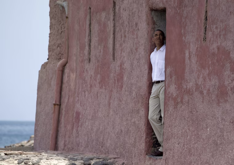 Image: President Barack Obama looks out of the \"door of no return\" during a tour of Goree Island, Senegal.