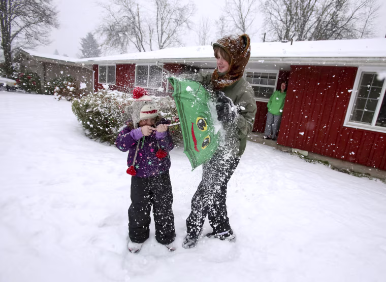 Image: Seven-year-old Juniper Jefferson (left) uses an umbrella to block a snowball from her brother, 13-year-old Aiden Jefferson, as the two played in the yard of their north Eugene, Oregon home on Jan. 7.
