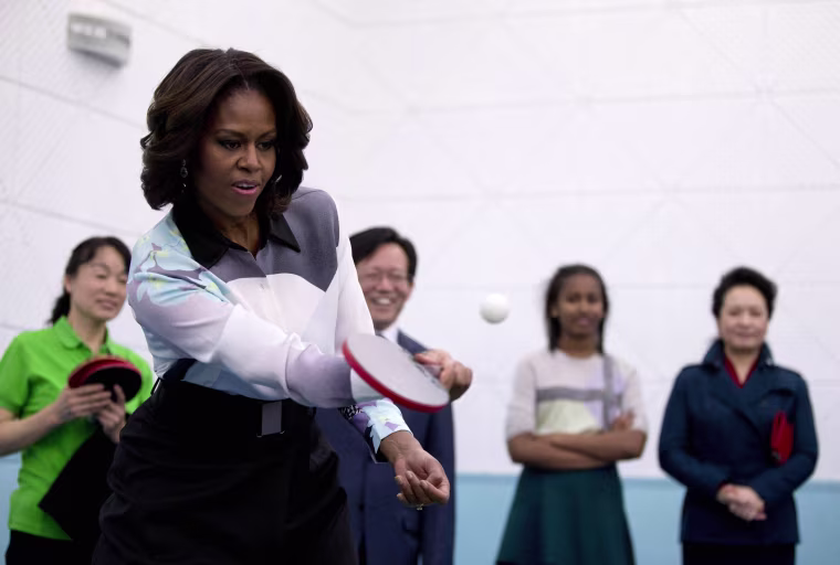 Image: U.S. first lady Michelle Obama plays table tennis during her visit of Beijing Normal School