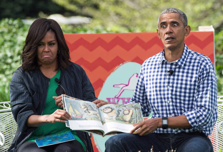 Image: US President Barack Obama and First Lady Michelle Obama read Maurice Sendak's \"Where the Wild Things Are\" to children at the annual Easter Egg Roll at the White House
