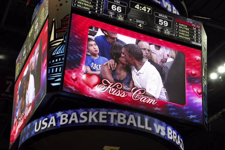 Image: U.S. President Obama and first lady Michelle Obama are shown kissing on the \"Kiss Cam\" screen during a timeout in the Olympic basketball exhibition game between the U.S. and Brazil national men's teams in Washington