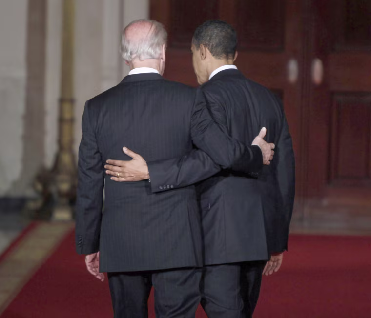 Image: U.S. President Barack Obama and Vice President Joe Biden walk arm-in-arm down the Cross Hall of the White House in Washington, March 21, 2010, after Obama spoke about the House of Representatives' final passage of health care legislation.