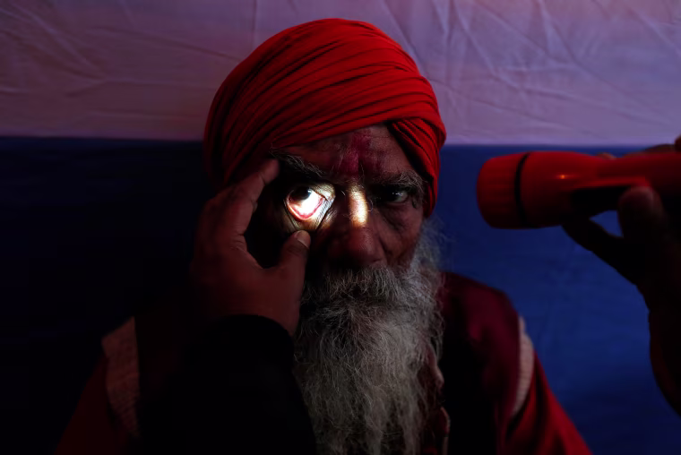 Image: A Sadhu or a Hindu holy man undergoes an eye examination at a free eye-care camp organized by social workers at a makeshift shelter, before heading for an annual trip to Sagar Island for the one-day festival of \"Makar Sankranti\", in Kolkata, India.