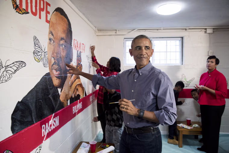 Image: President Barack Obama and First Lady Michelle Obama help paint a mural depicting Martin Luther King Jr., as Mayor of Washington, D.C. Muriel Bowser, right, looks on, at the Jobs Have Priority Naylor Road Family Shelter on Jan. 16 in Washington, D.