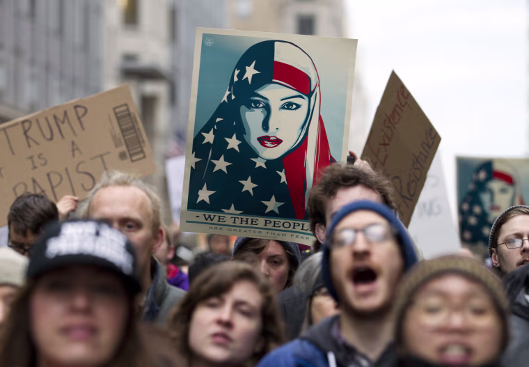 Image: Demonstrators march on the street near a security checkpoint