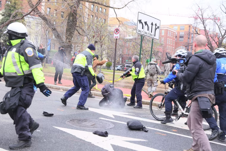 Image: Police arrest and detain a protester in the street in Washington, D.C. Protesters took to the streets to march against presidential inauguration of Donald Trump.