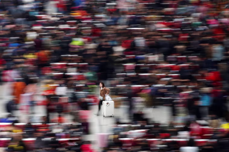Image: Passengers wait to board trains at Shanghai's Hongqiao Railway Station as hundreds of millions of Chinese travel home for Lunar New Year in Beijing and Shanghai, in Shanghai