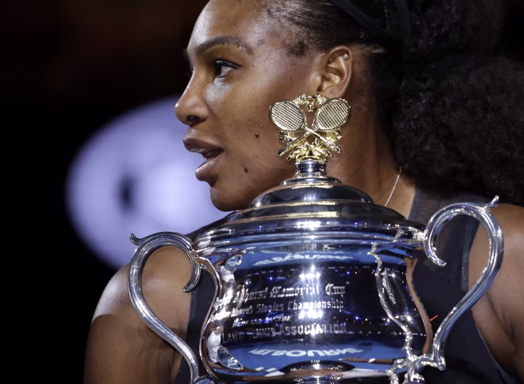 Image: United States' Serena Williams holds her trophy after defeating her sister Venus