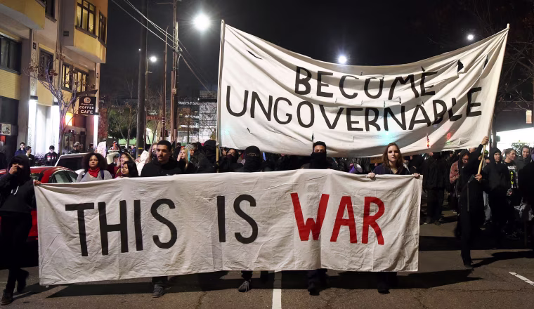 Image: Protesters march with signs in Berkeley