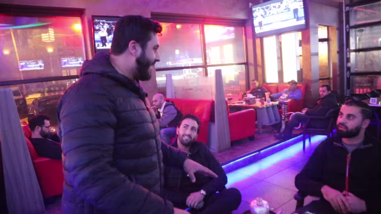 Image: Moe Qasim jumps into a conversation at the Signature Cafe hookah lounge