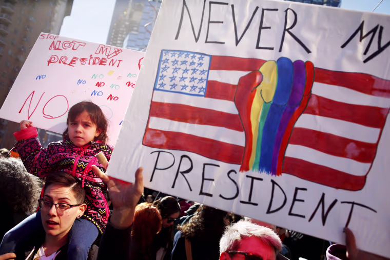 Image: People hold signs at a rally in New York, Feb. 20, 2017. Demonstrators unhappy with President Donald Trump's policies are attending a \"Not My Presidents Day\" rally on Central Park West near a Trump hotel.
