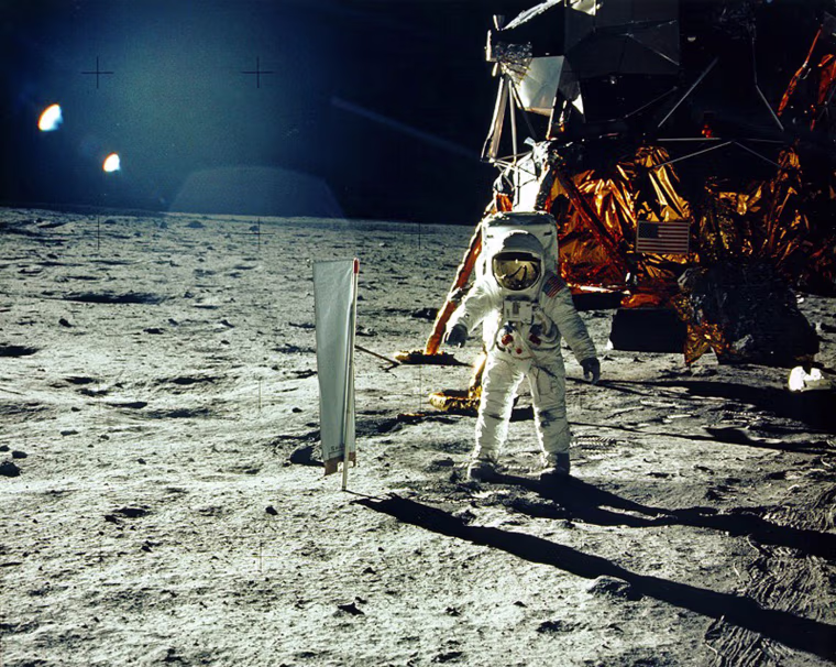 Image: United States astronaut Buzz Aldrin stands beside a solar wind experiment next to the Lunar Module spacecraft on the surface of the Moon