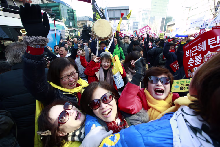 Image: South Koreans cheer after the court's ruling on the impeachment of President Park Geun-hye near the Constitutional Court.