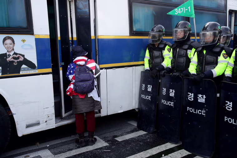 Image: A supporter of the South Korean president looks at a police bus during a protest against the court's ruling.