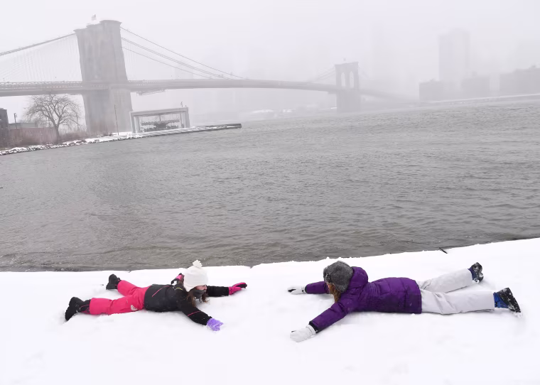 Image: Two girls make snow angels in Brooklyn Bridge Park