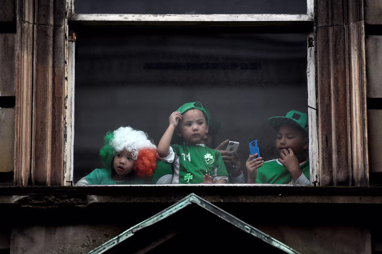 Image: Children watch the St. Patrick's day parade from a window in Dublin