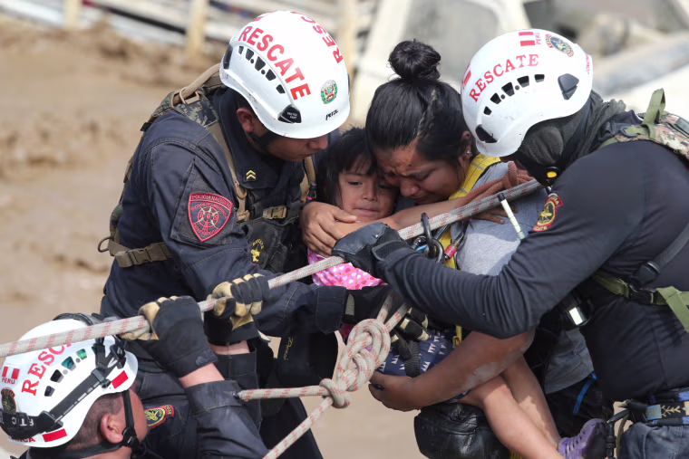 Image: A woman and a child get rescued after a massive landslide and flood in the Huachipa district of Lima, March 17.