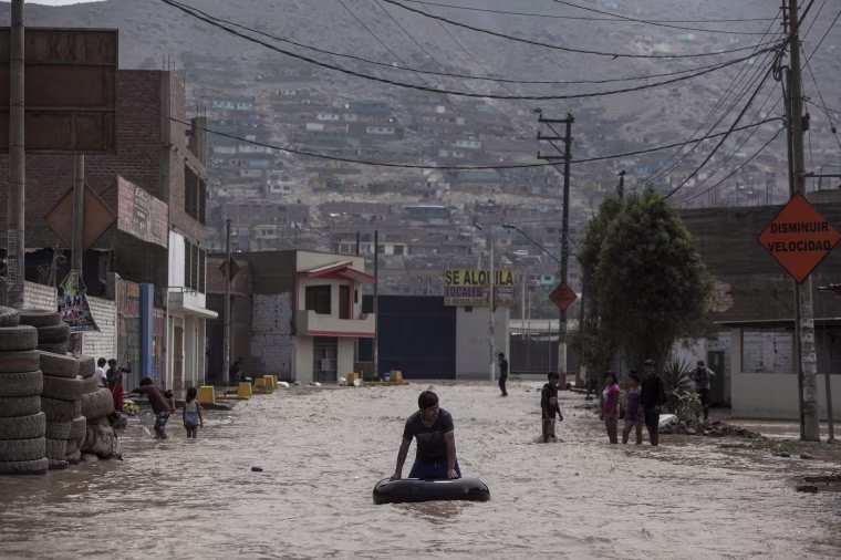 Image: A man plays in a flooded street using an inner tube in Lima, Peru, March 16, 2017.