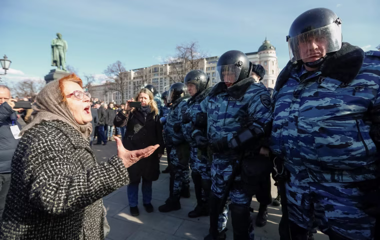 Image: A woman argues with law enforcement officers as they block the rally in Moscow.